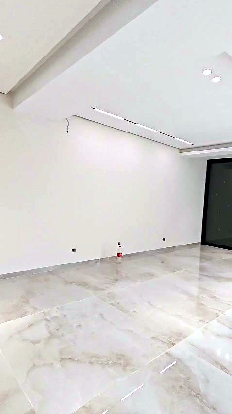 חלל מגורים עם ריצוף מבריק ותקרת גבס עם תאורה שקועה