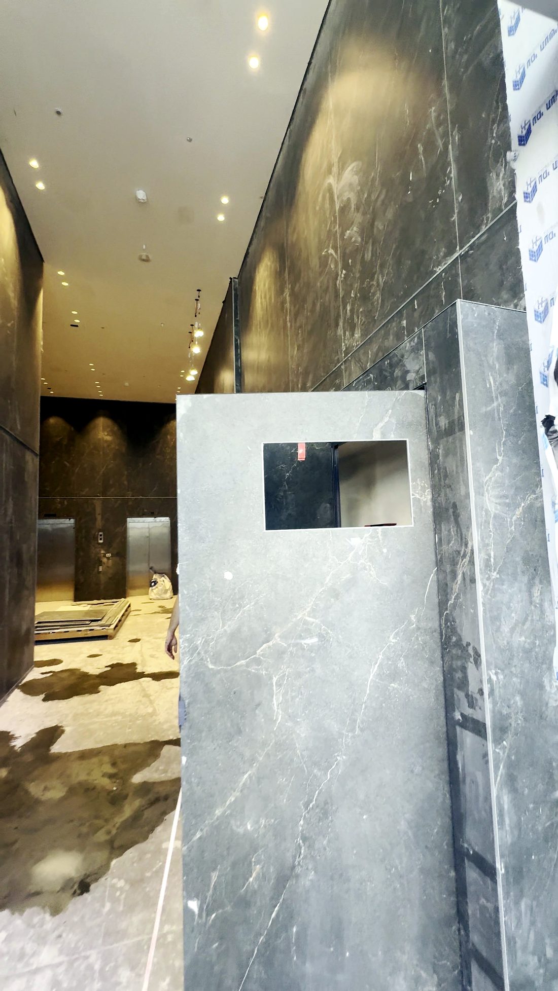 הלובי של Life Tower בזמן התקנת החיפוי, עם חומרים על הרצפה